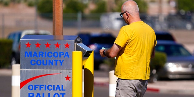 A voter places a ballot in an election voting drop box in Mesa, Ariz., Friday, Oct. 28, 2022.