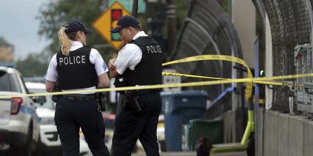 Chicago police officers guard a crime scene after a shooting at the CTA Red Line station at 79th Street on Aug. 8, 2022.