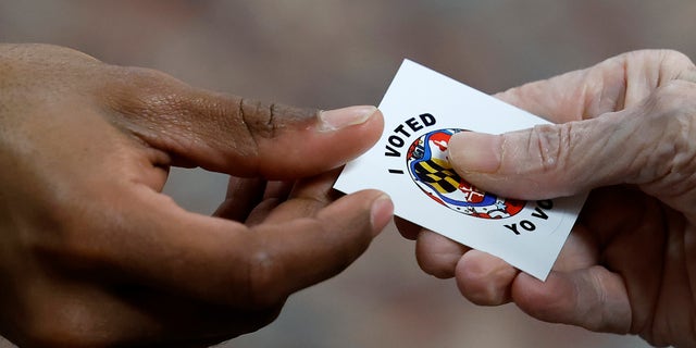 Voters get "I Voted" stickers after casting their ballots at the early voting location in the ballroom of the Sandy Spring Volunteer Fire Station on October 27, 2022 in Sandy Spring, Maryland.