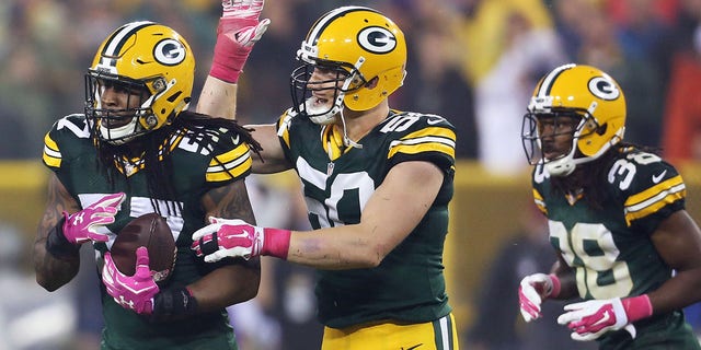 Jamari Lattimore #57 of the Green Bay Packers celebrates his interception with A.J. Hawk #50 during the second quarter of the NFL game against the Minnesota Vikings on Oct. 2, 2014 at Lambeau Field in Green Bay, Wisconsin. The Packers defeated the Vikings 42-10.