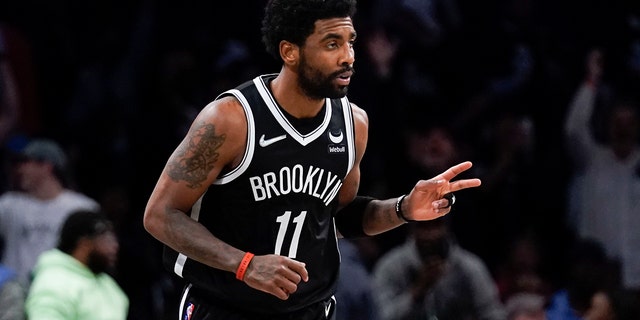 The Brooklyn Nets' Kyrie Irving reacts after hitting a basket against the Cleveland Cavaliers during the first half of the opening game of the NBA play-in tournament April 12, 2022, in New York.