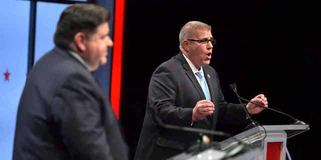 State Sen. Darren Bailey, right, the Republican candidate for Illinois governor, and incumbent Illinois Gob. JB Pritzker debate during the Illinois Governor's Debate on the stage in Braden Auditorium at the campus of Illinois State University in Normal, Ill., Thursday, Oct. 6, 2022 