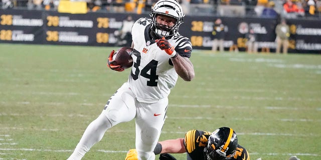 Cincinnati Bengals running back Samaje Perine, #34, runs away from Pittsburgh Steelers linebacker Robert Spillane, #41, on his way to a touchdown during the first half of an NFL football game, Sunday, Nov. 20, 2022, in Pittsburgh. 