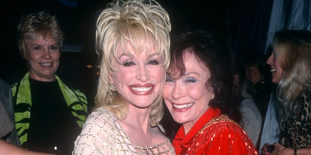 American singer and songwriter Dolly Parton poses with American country music singer-songwriter Loretta Lynn circa 1997 at the Grand Ole Opry in Nashville, Tennessee. 