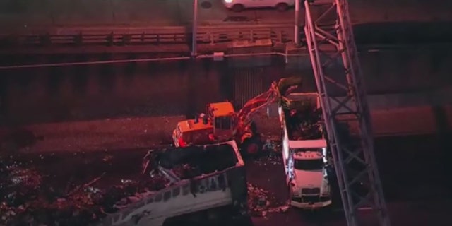 A crew cleans up debris on I-95 in New York after a fiery crash early Tuesday.