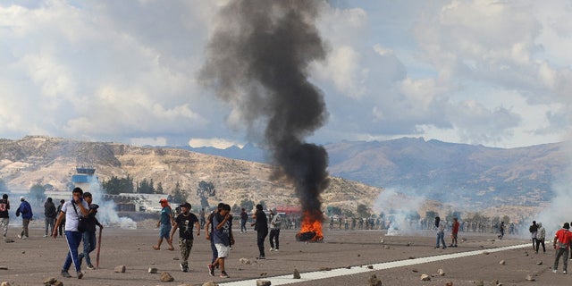 Demonstrators stand on an airport tarmac amid violent protests following the ousting and arrest of former President Pedro Castillo, in Ayacucho, Peru December 15, 2022. REUTERS/Miguel Gutierrez Chero.