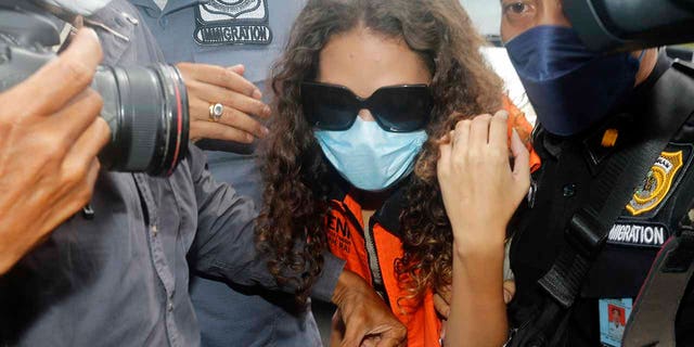 Heather Mack of Chicago, Ill., center, escorted by immigration officers to Immigration detention center in Jimbaran, Bali, Indonesia on Friday, Oct. 29, 2021. 
