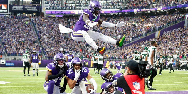 Minnesota Vikings safety Camryn Bynum (24) celebrates with teammates after intercepting a pass during the second half of an NFL football game against the New York Jets, Sunday, Dec. 4, 2022, in Minneapolis.