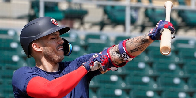 Minnesota Twins' Carlos Correa adjusts his arm protector during batting practice at Hammond Stadium, March 23, 2022, in Fort Myers, Fla.