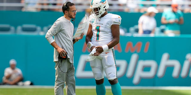 Miami Dolphins head coach Mike McDaniel talks with Miami Dolphins quarterback Tua Tagovailoa (1) during a stoppage in play in a game against the New England Patriots Sept. 11, 2022, at Hard Rock Stadium in Miami Gardens, Fla.