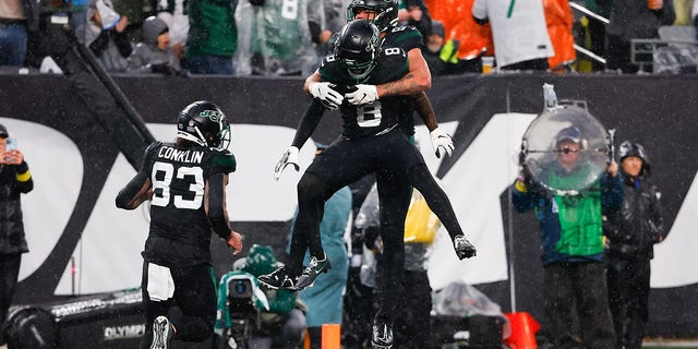 New York Jets wide receiver Elijah Moore (8) celebrates with tight end C.J. Uzomah after scoring a touchdown against the Chicago Bears on Nov. 27, 2022, at MetLife Stadium in East Rutherford, New Jersey.