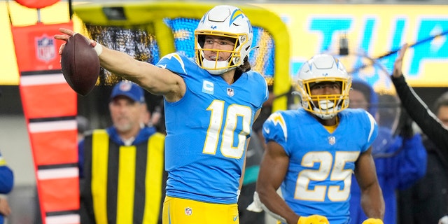 Los Angeles Chargers quarterback Justin Herbert (10) signals as he runs for a first down during the second half of a game against the Miami Dolphins Sunday, Dec. 11, 2022, in Inglewood, Calif. 