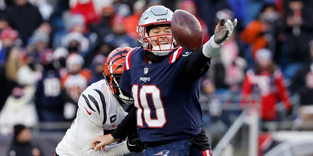 Vonn Bell #24 of the Cincinnati Bengals pressures Mac Jones #10 of the New England Patriots as he attempts a pass during the fourth quarter at Gillette Stadium on December 24, 2022 in Foxborough, Massachusetts.