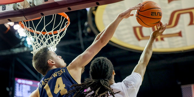 Notre Dame Fighting Irish forward Nate Laszewski, #14, blocks a shot attempt by Florida State Seminoles guard Caleb Mills, #4, at the Donald L. Tucker Center in Tallahassee, Florida, Dec. 21, 2022 during the second half of their game.