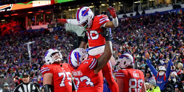 Nyheim Hines #20 of the Buffalo Bills celebrates with Dion Dawkins #73 after scoring a touchdown against the Miami Dolphins during the second quarter of the game at Highmark Stadium on December 17, 2022 in Orchard Park, New York. 