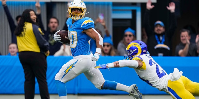 Los Angeles Chargers running back Austin Ekeler (30) evades a tackle from Los Angeles Rams safety Taylor Rapp as he runs toward the end zone for a touchdown during the first half of an NFL football game Sunday, Jan. 1, 2023, in Inglewood, Calif. 