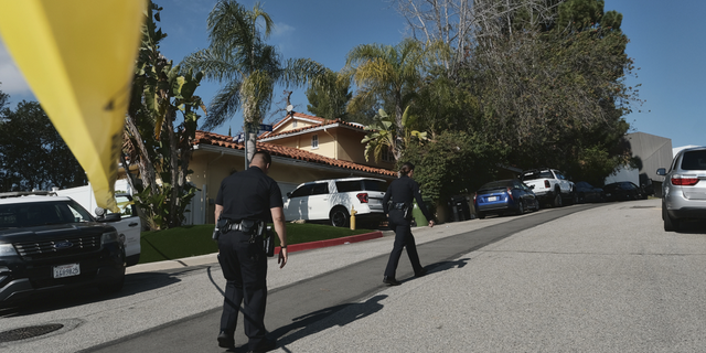 Police block the street to a house where three people were killed and four others wounded in a shooing at a short-term rental home in an upscale Los Angeles neighborhood on Saturday, Jan. 28.