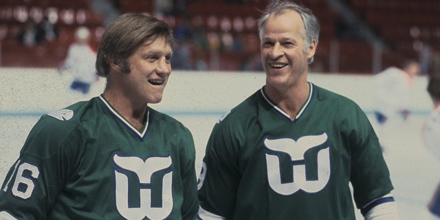 Gordie Howe #9 and Bobby Hull #16 of the Hartford Whalers look on against the Montreal Canadiens in the 1980's at the Montreal Forum in Montreal, Quebec, Canada.