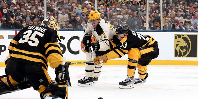 Evgeni Malkin #71 of the Pittsburgh Penguins and Charlie McAvoy #73 of the Boston Bruins compete for the puck during the first period in the 2023 Discover NHL Winter Classic at Fenway Park on January 02, 2023 in Boston, Massachusetts. 