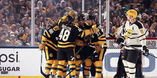 Jake DeBrusk #74 of the Boston Bruins celebrates with teammates after scoring a goal against the Pittsburgh Penguins during the third period in the 2023 Discover NHL Winter Classic at Fenway Park on January 02, 2023 in Boston, Massachusetts. 