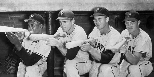 Pittsburgh Pirates "Big Guns" Roberto Clemente, Frank Thomas, Lee Walls, and Bill Virdon (L to R) set their sights on the National League pennant in this pose in their dugout.