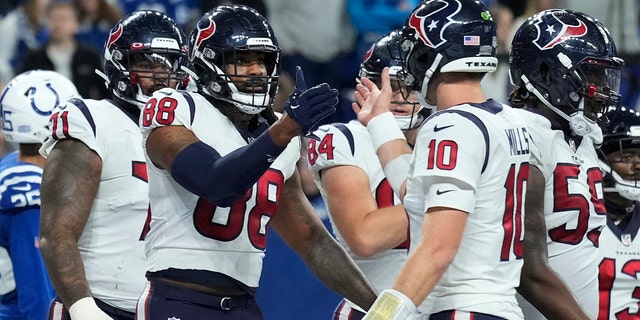 Houston Texans tight end Jordan Akins (88) is congratulated by quarterback Davis Mills (10) after scoring a two-point conversion during the second half, Jan. 8, 2023, in Indianapolis.