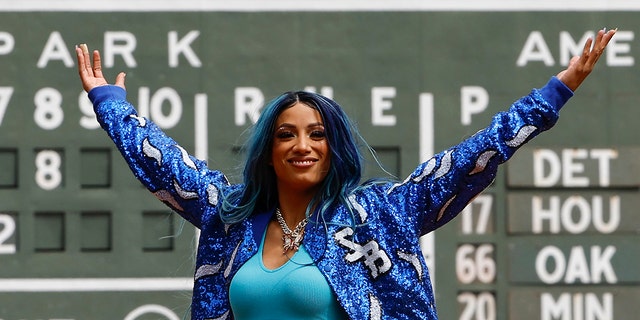 Six-time WWE Women's Champion Sasha Banks holds up her arms after throwing out the first pitch before the game between the Boston Red Sox and the Chicago White Sox at Fenway Park on May 8, 2022 in Boston.