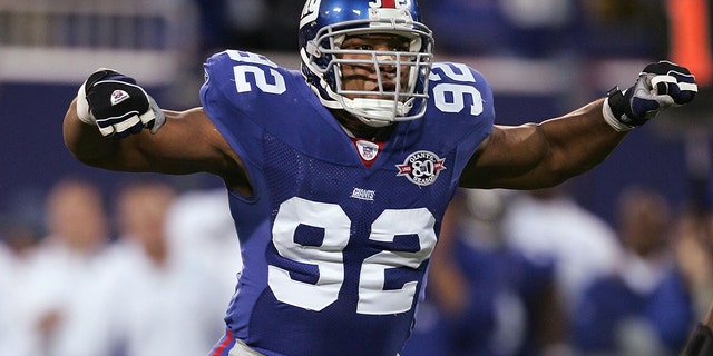 Defensive end Michael Strahan #92 of the New York Giants celebrates a sack of quarterback Craig Krenzel #16 of the Chicago Bears on November 7, 2004 at Giants Stadium in East Rutherford, New Jersey.