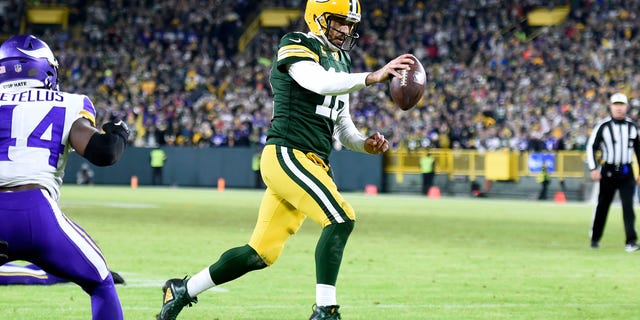Aaron Rodgers #12 of the Green Bay Packers runs for a two yard touchdown during the fourth quarter Minnesota Vikings at Lambeau Field on January 01, 2023 in Green Bay, Wisconsin.