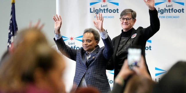 Chicago mayor Lori Lightfoot, left, and her spouse Amy Eshleman wave to supporters during Women for Lori Rally in Chicago, Saturday, Feb. 25, 2023.