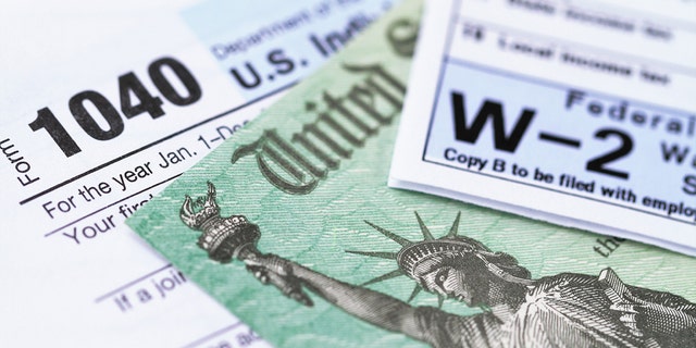 1040 income tax form and W-2 wage statement with a federal Treasury refund check. 
