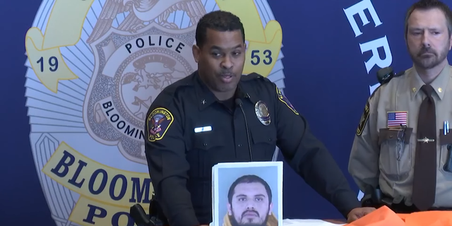 Bloomington Police Chief Booker Hodges holds up mug shot of man arrested for allegedly soliciting sex in a prostitution sting.