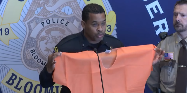 Bloomington Police Chief Booker Hodges holds up an orange jumpsuit after prostitution sting.