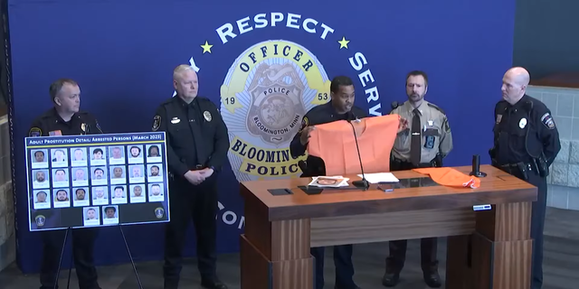 Bloomington Police Chief Booker Hodges holds up an orange jumpsuit after prostitution sting.