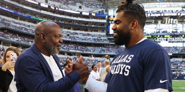 Emmitt Smith, former Dallas Cowboys running back, left shakes hands with Ezekiel Elliott, #21 of the Dallas Cowboys, before a game against the Chicago Bears at AT&amp;T Stadium on Oct. 30, 2022 in Arlington, Texas.