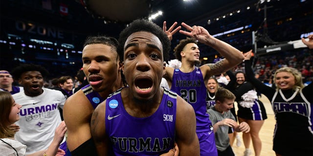 JP Pegues #1 of the Furman Paladins celebrates the win against the Virginia Cavaliers during the first round of the 2023 NCAA Men's Basketball Tournament held at Amway Center on March 16, 2023 in Orlando, Florida.