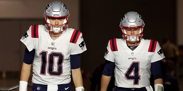 Mac Jones, left, and Bailey Zappe of the New England Patriots take the field before the Cardinals game at State Farm Stadium on Dec. 12, 2022, in Glendale, Arizona.