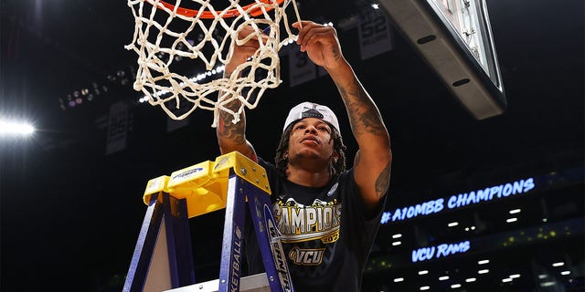 Adrian Baldwin Jr. #1 of the Virginia Commonwealth Rams cuts down the net after defeating Dayton Flyers to win the A10 Basketball Tournament Championship at Barclays Center on March 12, 2023 in New York City. Virginia Commonwealth Rams defeated Dayton Flyers 68-56.