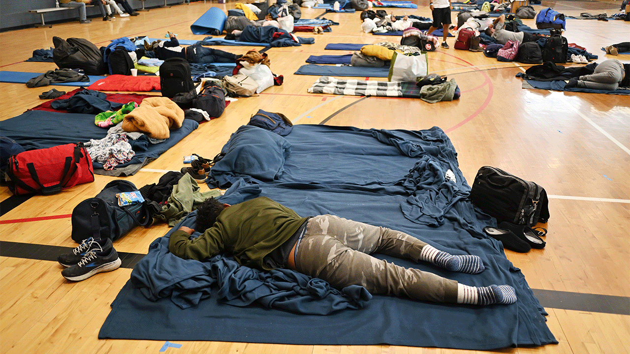A migrant lying on a sleeping pad at a makeshift shelter in Denver on Friday, Jan. 13, 2023. 