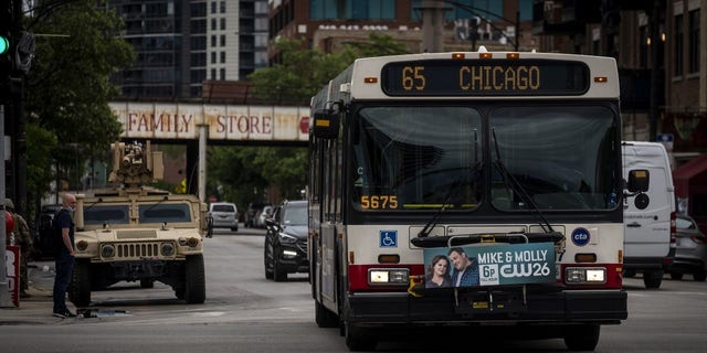 A Chicago Transit Authority (CTA) bus passes a National Guard vehicle in Chicago, Illinois, U.S., on Wednesday, June 3, 2020. 