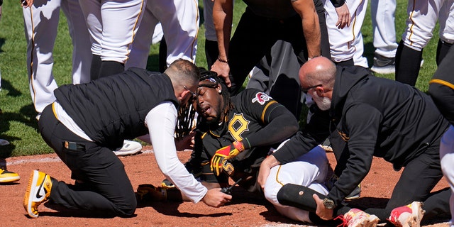 Pittsburgh Pirates' Oneil Cruz, center, is tended to by team trainers after colliding with Chicago White Sox catcher Seby Zavala attempting to score during the sixth inning of a baseball game in Pittsburgh, Sunday, April 9, 2023. A bench clearing brawl ensued as a result of the play. The Pirates won 1-0.