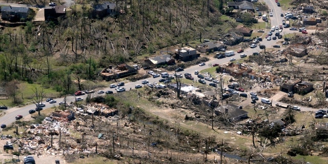 Cars line up along the road as cleanup continues from Friday's tornado damage, Sunday, April 2, 2023, in west Little Rock, Ark. 