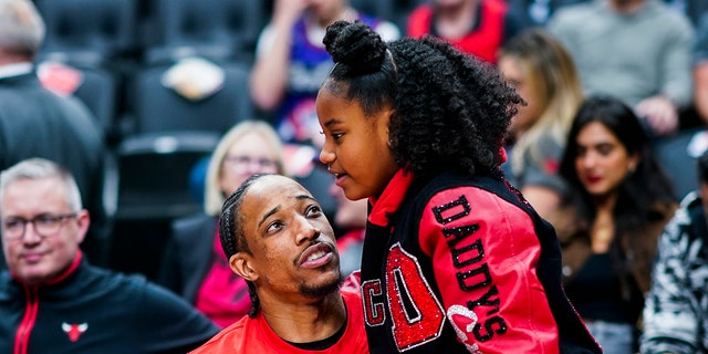 DeMar DeRozan of the Chicago Bulls embraces his daughter before the Raptors game on April 12, 2023, in Toronto.