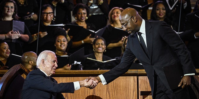 Sen. Raphael Warnock greets President Joe Biden during a worship service in Atlanta, Georgia, on Jan. 15, 2023, ahead of Martin Luther King, Jr. Day. Despite Warnock's win in Georgia, the DNC opted to host the 2024 convention in Illinois. 
