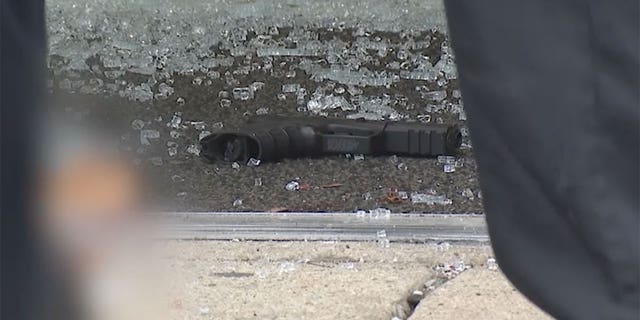 Multiple bullet holes riddled the vestibule, along with shattered glass out front of the building. A gun was also seen near the entrance to the store.