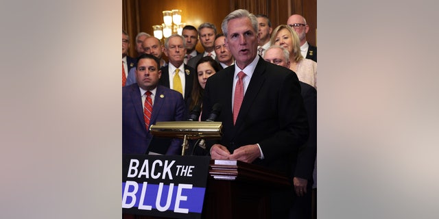 House Speaker McCarthy by Back the Blue sign 