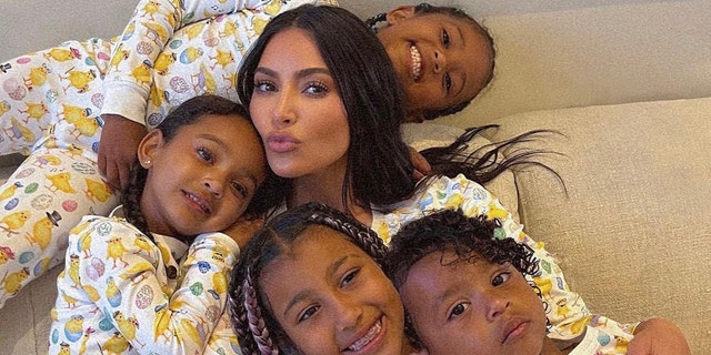 Kim Kardashian snuggles up with her four children: North, Saint, Chicago, and Psalm all wearing matching pajamas for Easter