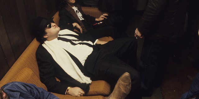 Blues brother John Belushi sits backstage after a show