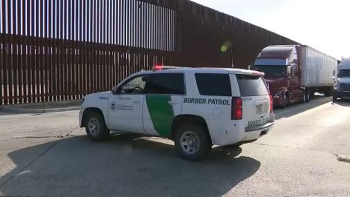 Authorities investigate the scene after a woman fell from the US-Mexico border wall near Otay Mesa