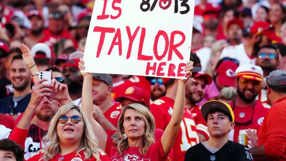 Female fan holding Taylor Swift, Travis Kelce sign